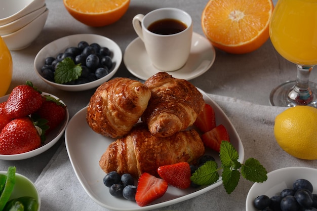 Sabroso desayuno Croissants frutas frescas y secas jugo fresco