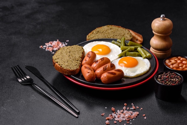 Sabroso desayuno inglés de huevos fritos frijoles espárragos salchichas con especias y hierbas