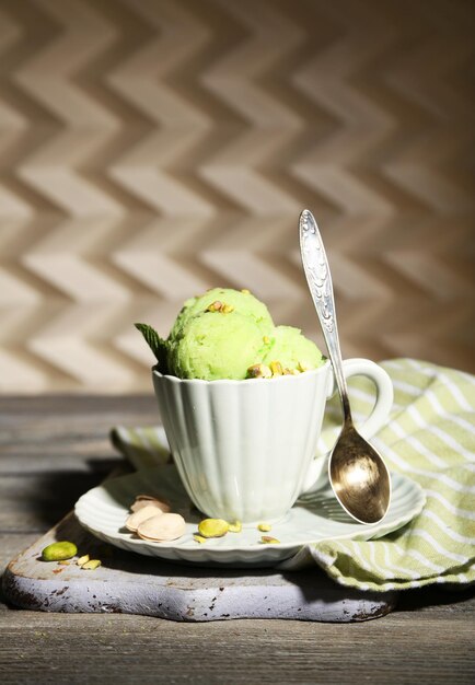 Foto sabroso helado de pistacho en taza sobre mesa de madera