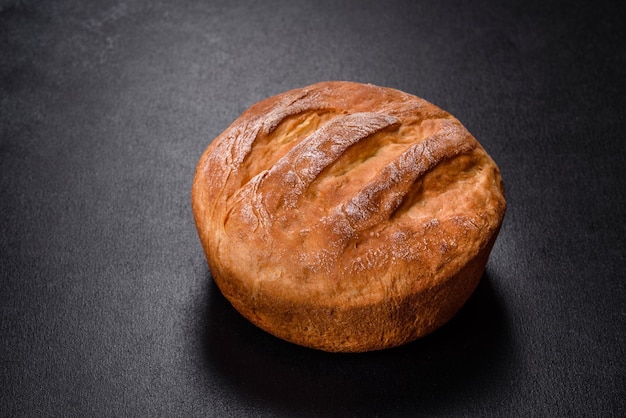 Sabroso pan blanco recién horneado en horno sobre un fondo de hormigón oscuro