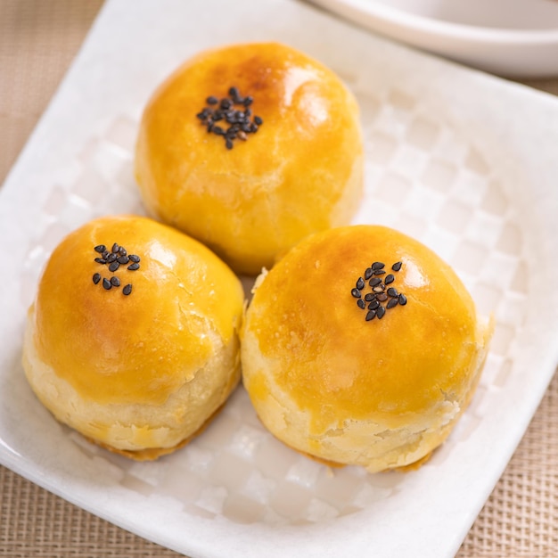 Sabroso pastel de luna de yema de huevo horneado para el Festival del Medio Otoño sobre fondo de mesa de madera brillante Concepto de comida festiva china cerrar espacio de copia