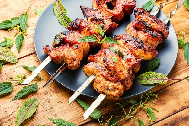 Sabroso pinchito en brochetas con marinada de ortiga. Shish kebab sobre fondo de madera