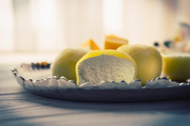 Sabroso postre Mochi con fruta de mango sobre fondo de madera