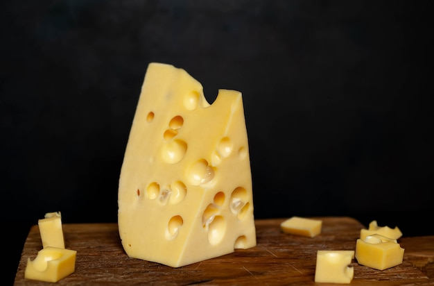 sabroso queso en una tabla de cortar sobre un fondo de piedra