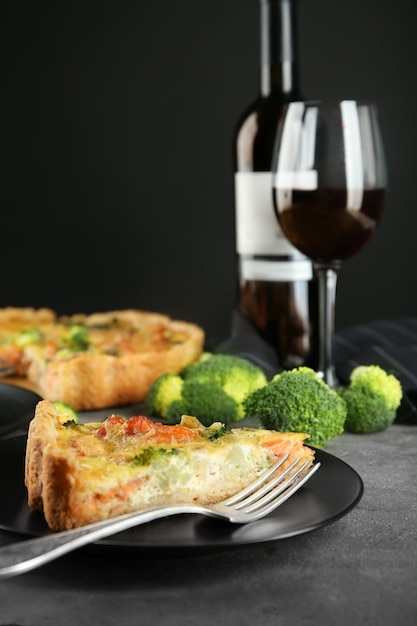 Sabroso quiche de brócoli servido con vino en la mesa