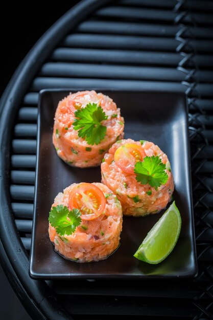 Sabroso y saludable tartar de salmón con tomates cherry y lima