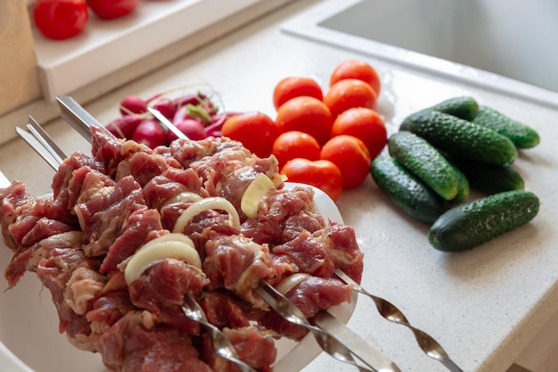 Sabrosos y apetitosos pinchos de carne cruda en el fondo de la cocina moderna