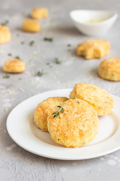 Sabrosos bollos o galletas con queso y tomillo en un plato de cerámica blanca.