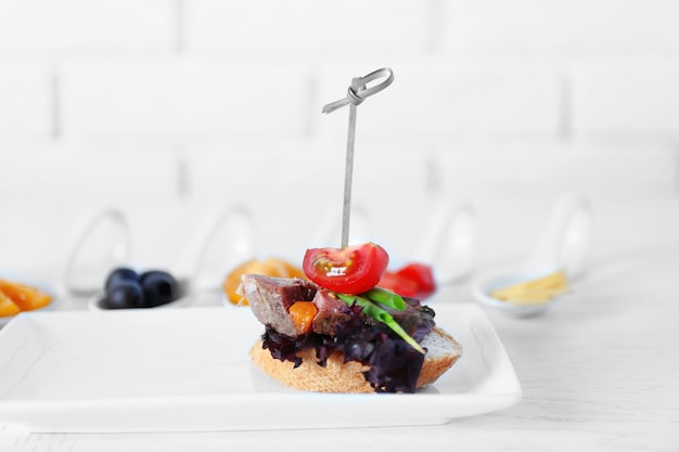 Foto sabrosos canapes en una mesa de madera de cerca