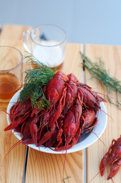 Sabrosos cangrejos cocidos y cerveza en mesa vieja