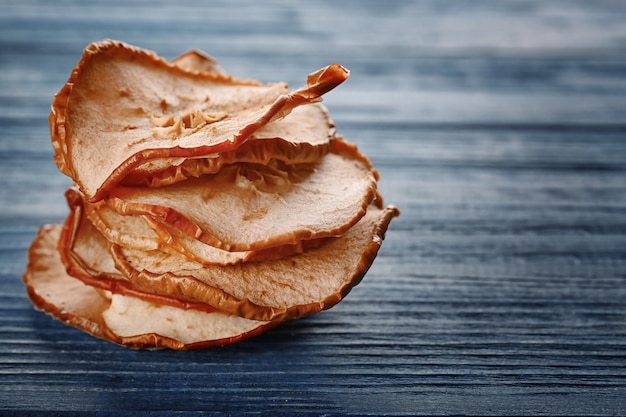 Sabrosos chips de manzana en la mesa de madera