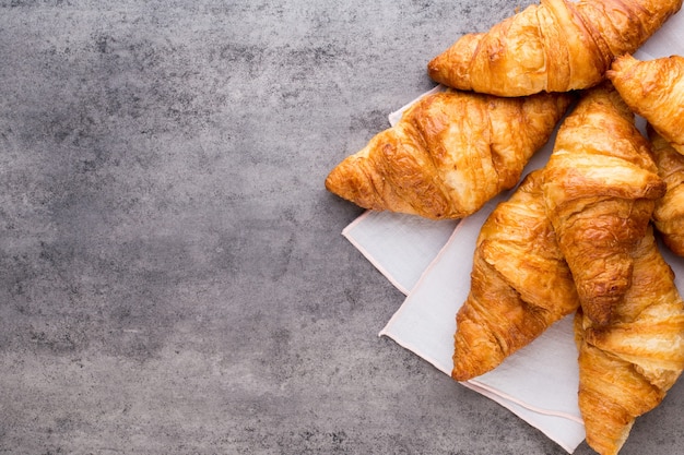 Sabrosos croissants de mantequilla en la mesa de madera vieja.