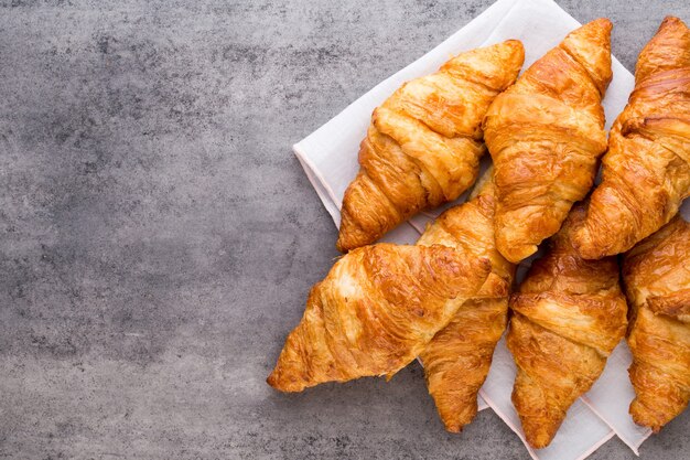 Sabrosos croissants de mantequilla en la mesa de madera vieja.