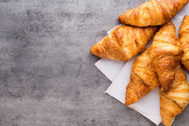 Sabrosos croissants de mantequilla en la mesa de madera vieja.