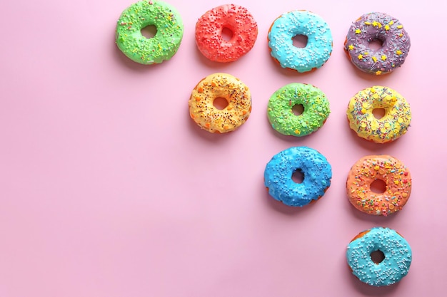 Sabrosos donuts glaseados sobre fondo de color
