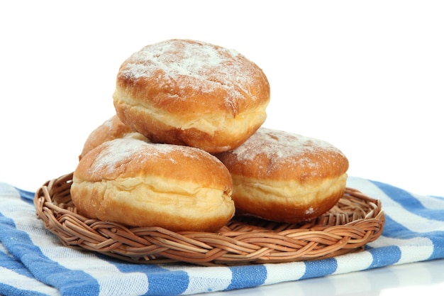 Sabrosos donuts en plato de mimbre aislado en blanco