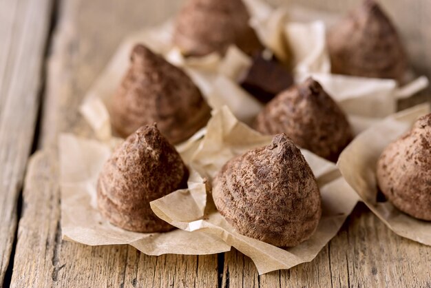 Foto sabrosos dulces caseros de trufa de chocolate en el antiguo fondo de madera sabroso postre de cerca