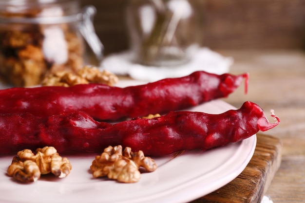 Foto sabrosos dulces orientales churchkhela y nueces frescas sobre fondo de madera