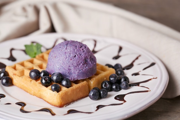 Foto sabrosos gofres belgas con helado en mesa de madera