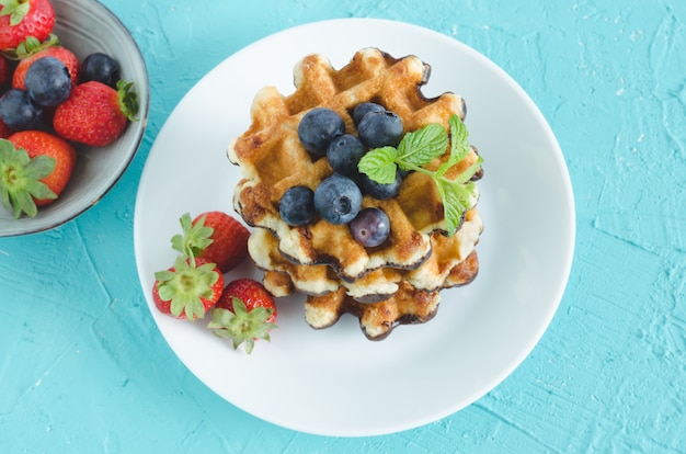 Sabrosos gofres con frutas en un plato blanco