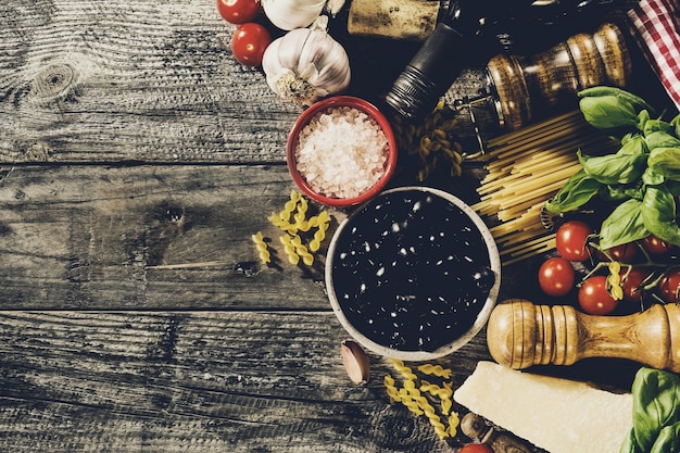 Foto sabrosos ingredientes italianos apetitosos de comida italiana en antiguo fondo de madera rústica. listo para cocinar. inicio italiano comida saludable concepto de cocina. viraje.