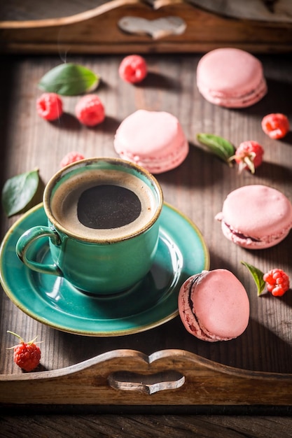 Sabrosos macarrones rosados servidos con café caliente