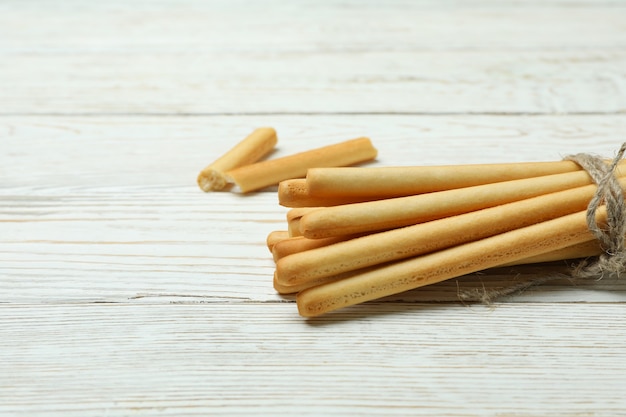 Foto sabrosos palitos de pan grissini en madera blanca