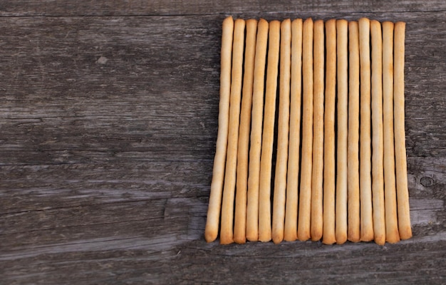 Sabrosos palitos de pan italiano sobre fondo de madera con espacio para copiar