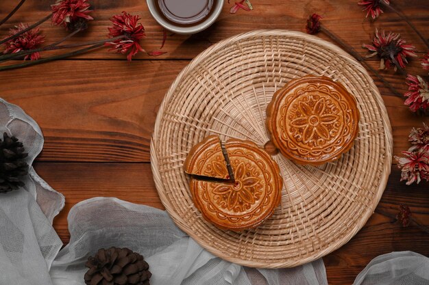 Sabrosos pasteles de luna y té sobre fondo de madera para la celebración del Festival Chino del Medio Otoño