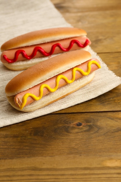 Sabrosos perros calientes en mesa de madera