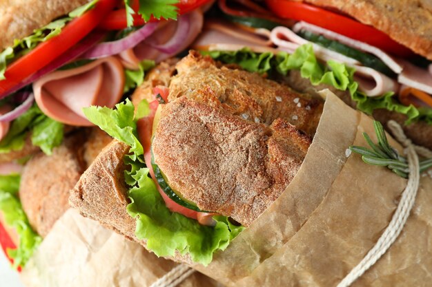 Sabrosos sándwiches de chapata en papel artesanal, cerrar