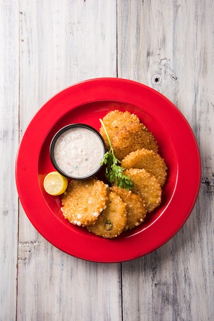 Sabudana o Sago Vada es un bocadillo frito tradicional de la India. Servido con chutney verde picante o de maní. Servir en plato de madera sobre fondo de colores o madera. Enfoque selectivo