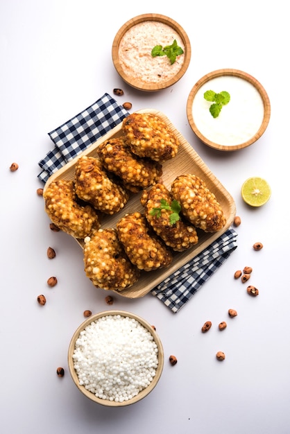 Sabudana vada ou bolo frito de sagu servido com chutney de amendoim sobre fundo temperamental, popular receita de jejum da Índia.