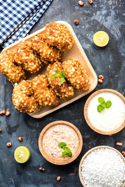 Sabudana vada ou bolo frito de sagu servido com chutney de amendoim sobre fundo temperamental, popular receita de jejum da Índia.