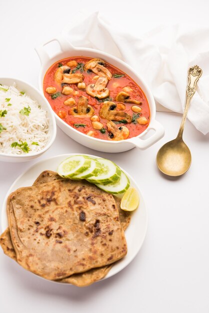 Sabzi de cogumelos ao curry de tomate com grão de bico e espinafre, prato principal indiano servido com paratha e arroz branco cozido