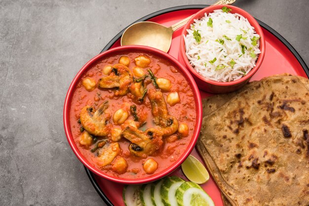 Sabzi de cogumelos ao curry de tomate com grão de bico e espinafre, prato principal indiano servido com paratha e arroz branco cozido