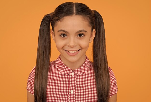 Foto saca a relucir la belleza interior retrato de niña feliz fondo naranja retrato de cara de niño siéntete hermosa