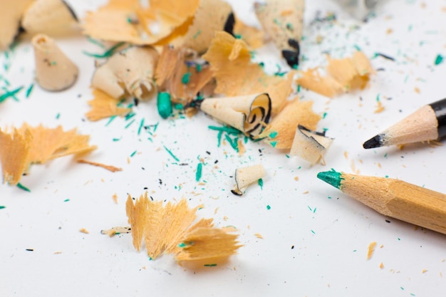 Sacapuntas y virutas de un lápiz roto y un grafito sobre fondo blanco Primer plano Fotografía macro Concepto de regreso a la escuela