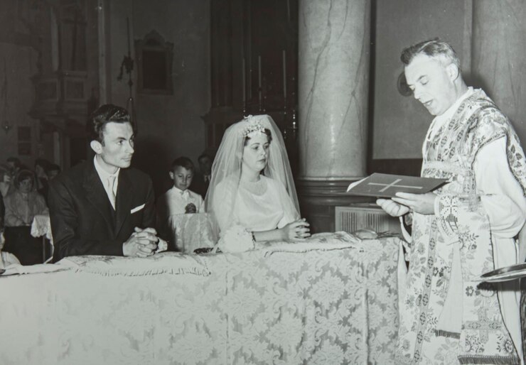 Sacerdote celebrando uma cerimônia de casamento na igreja durante os anos 60 ou 70