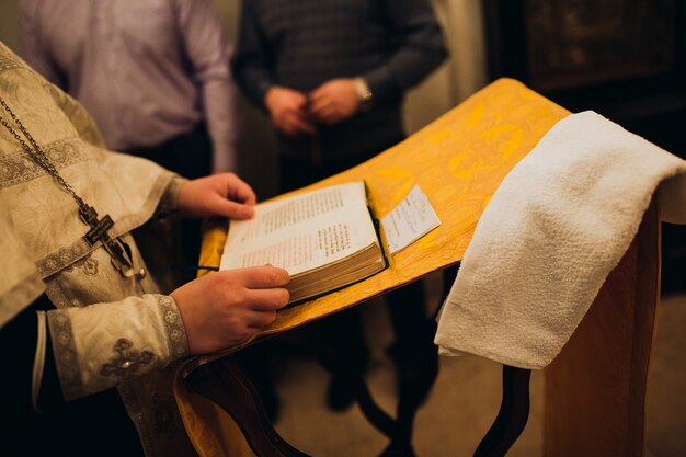 Sacerdote cristão ortodoxo e Bíblia Sagrada na igreja. Rito da cerimônia de epifania.