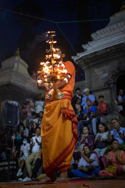 Sacerdote do Templo Pashupatinath, Patrimônio Mundial da UNESCO, realizando a cerimônia de Arati à noite