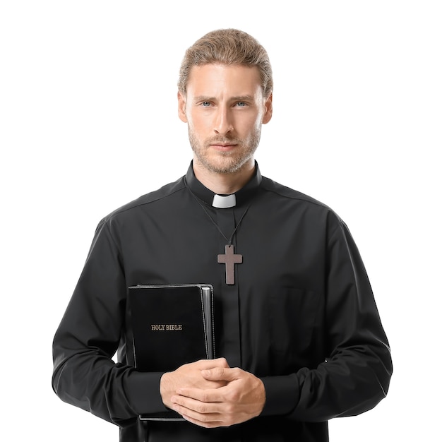 Sacerdote guapo con Biblia sobre fondo blanco.