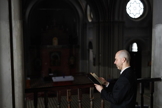 Foto sacerdote leyendo la biblia en la iglesia