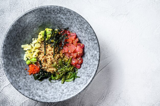 Sackschale mit rohem Thunfisch und Gemüse. Hawaiianisches Gericht. Konzept für gesunde Ernährung. Grauer Hintergrund