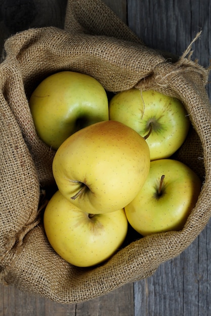 Foto saco de arpillera con manzanas amarillas melinda