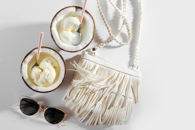 Saco branco e sorvete ao meio de coco. Conceito de férias de verão.