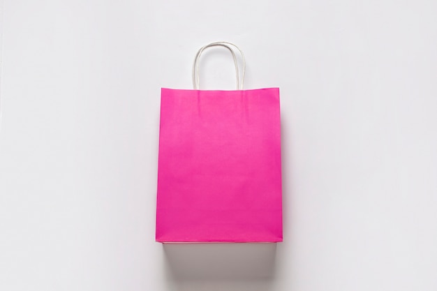 Foto saco de compras rosa sobre fundo branco. conceito de compras, desconto, venda.