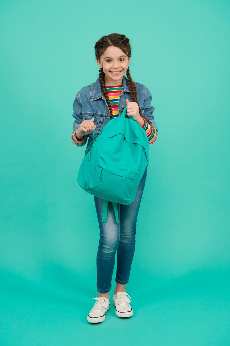 Foto saco de conhecimento garoto feliz segura mochila pesada fundo azul dia do conhecimento de volta à escola educação e estudo ensino particular startup 1 de setembro habilidades de habilidades de conhecimento