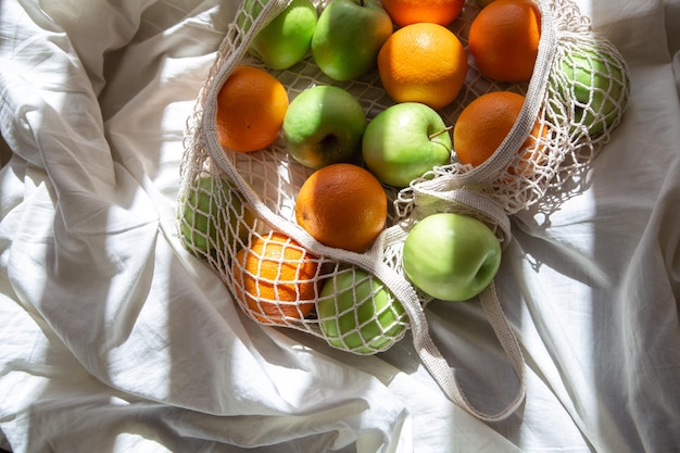 Saco de corda com frutas na cama com raios de sol