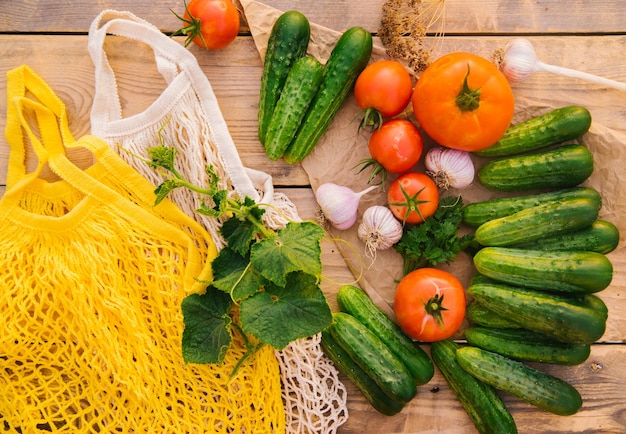 Saco de corda reutilizável feito de materiais reciclados em uma mesa de madeira entre legumes frescos Sem plástico Estilo de vida ecológico